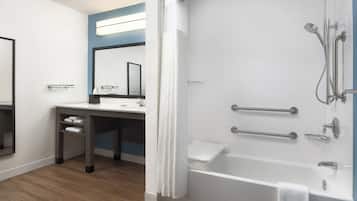 A modern bathroom with a shower, a sink, and a mirror.