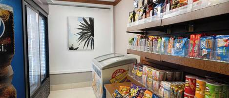 A snack and ice cream display in a store with a freezer and various packaged snacks.