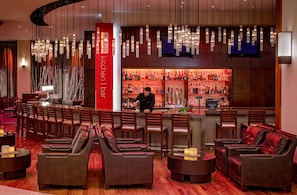 A bar area with leather seating, a bartender, and a well-stocked liquor shelf. - Hyatt Regency St. Louis at The Arch (St. Louis)