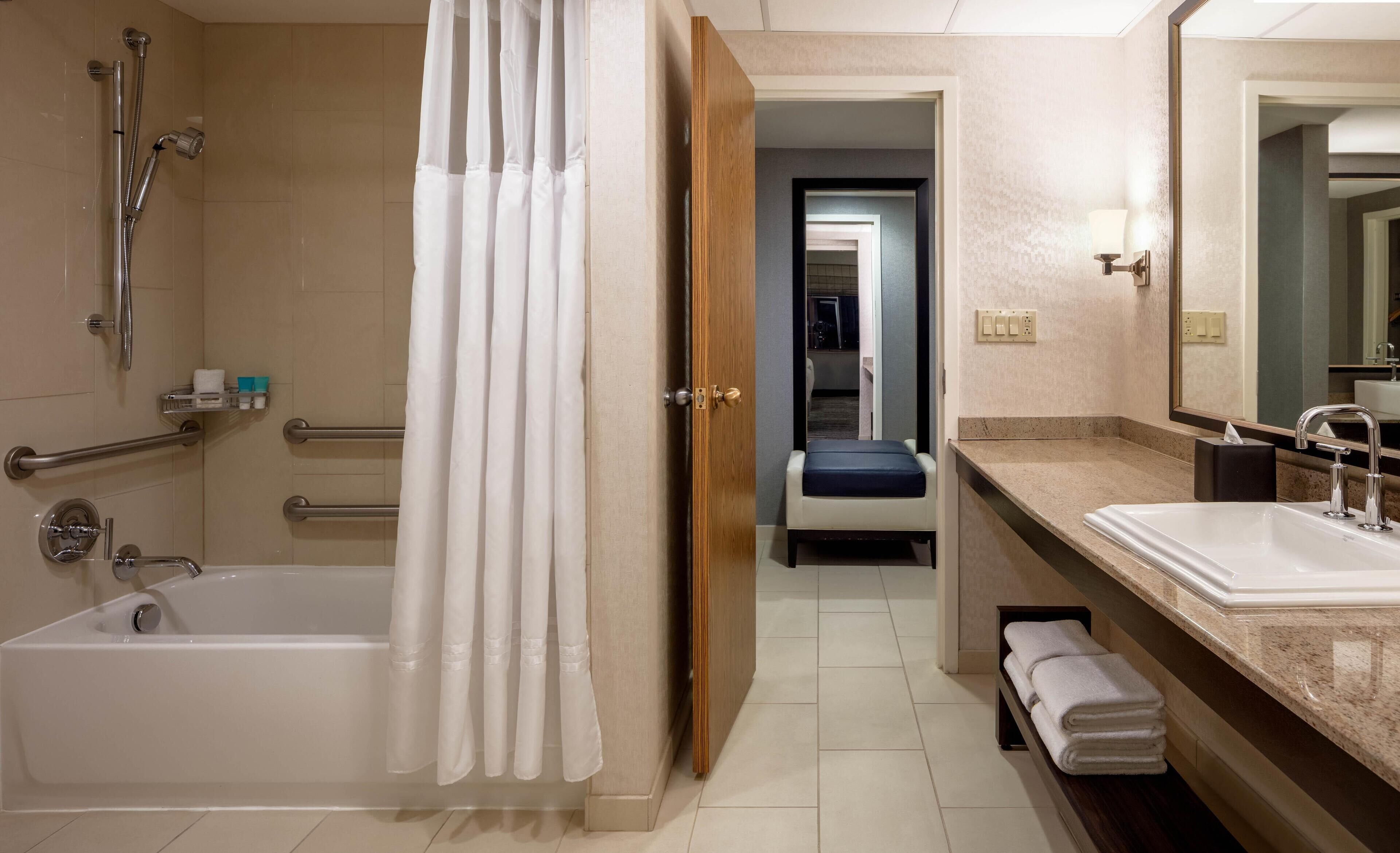 Un bagno moderno con vasca, doccia e mobile lavabo.