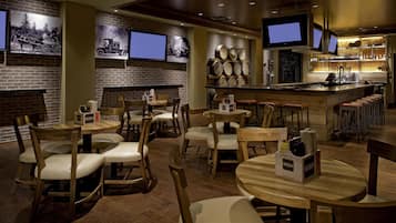 Ein Restaurant mit Ziegelwänden, Holztischen und -stühlen sowie einer Theke mit einem Fernseher.