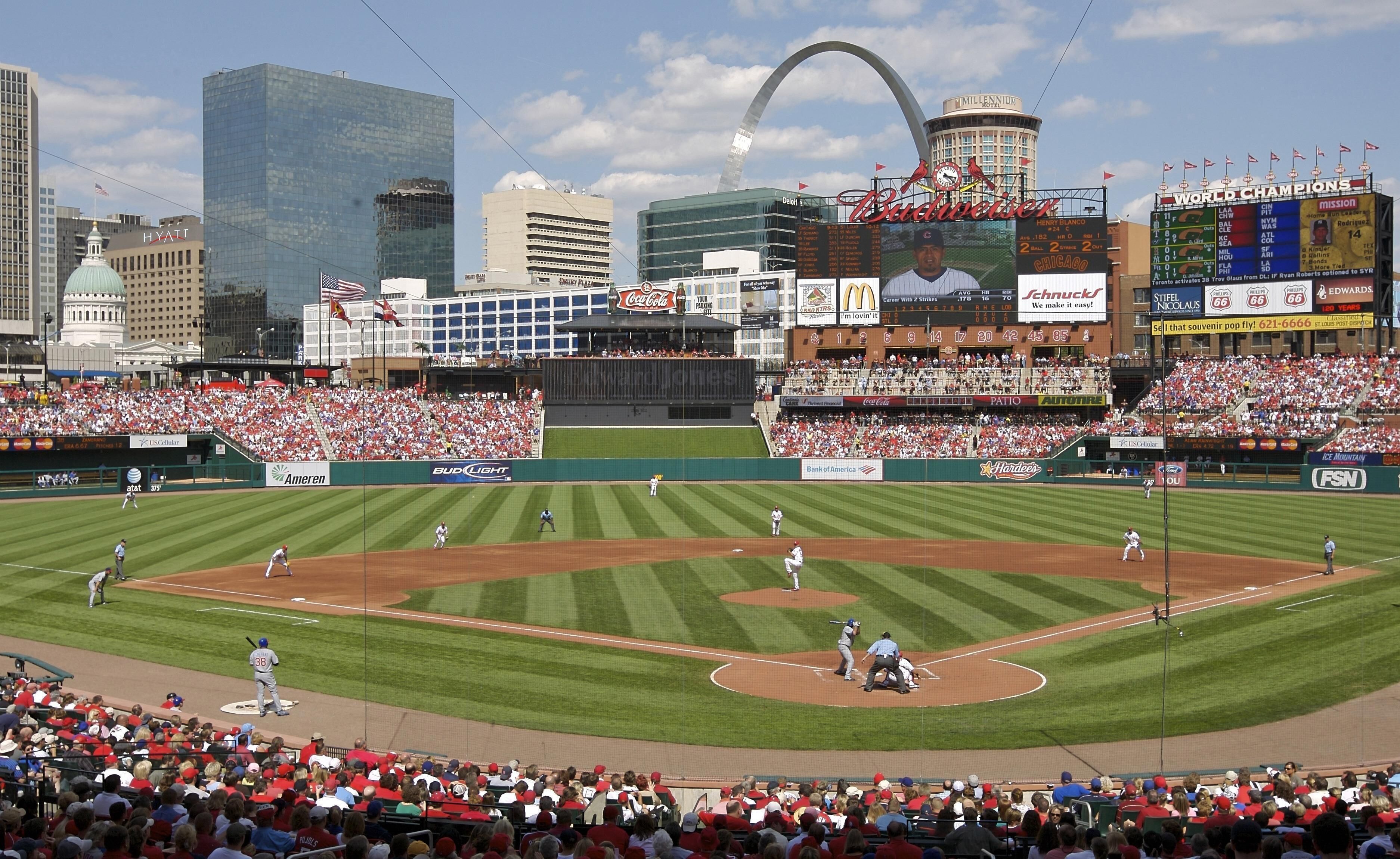 Un estadio de béisbol con una multitud numerosa, publicidad y un marcador.