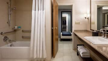 A modern bathroom with a bathtub, shower, and vanity.
