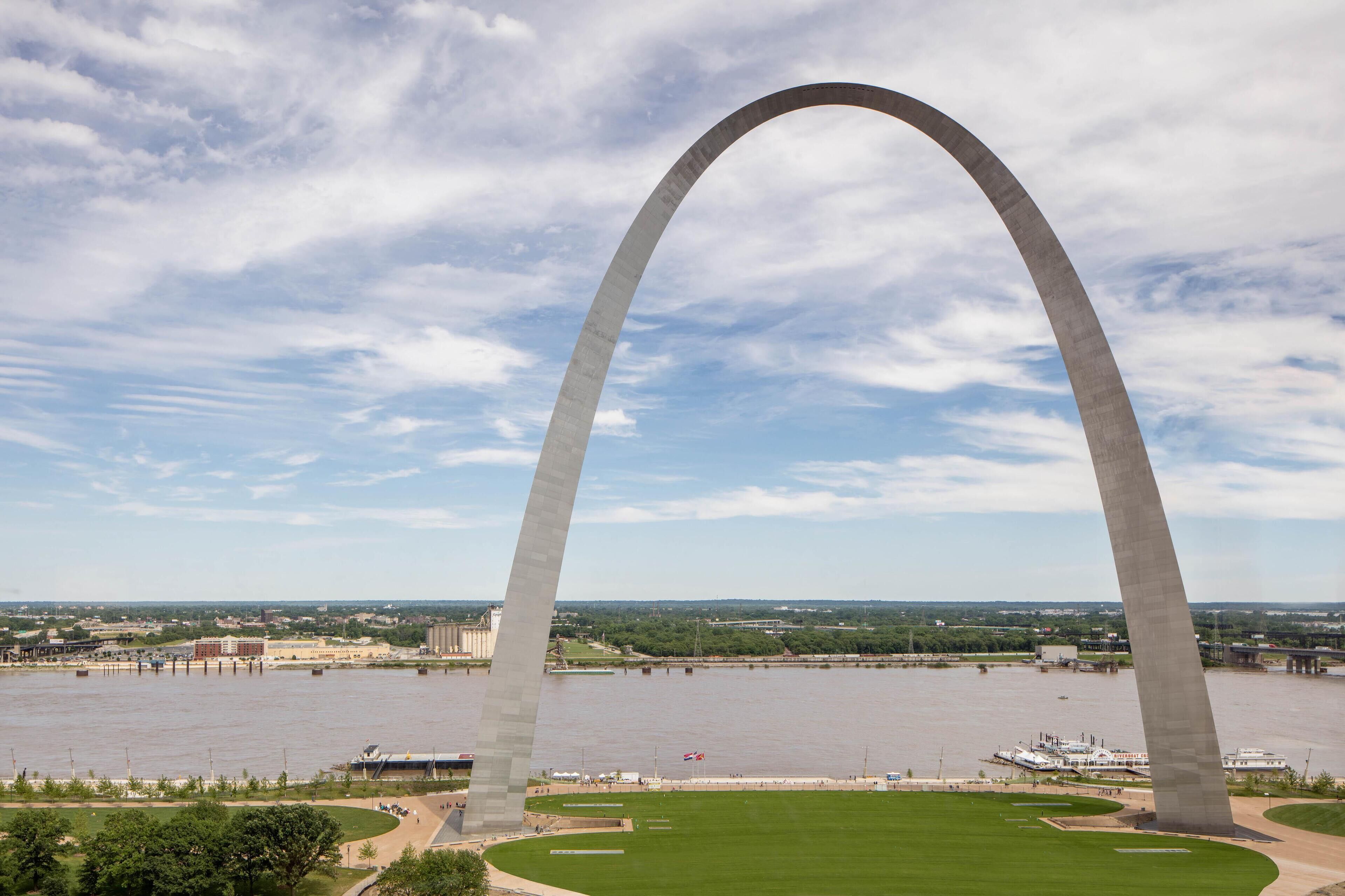 A large arch structure over a body of water with a clear sky.
