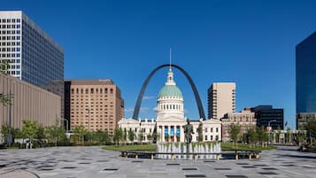 A large public square with a prominent building featuring a dome and a statue in the center.