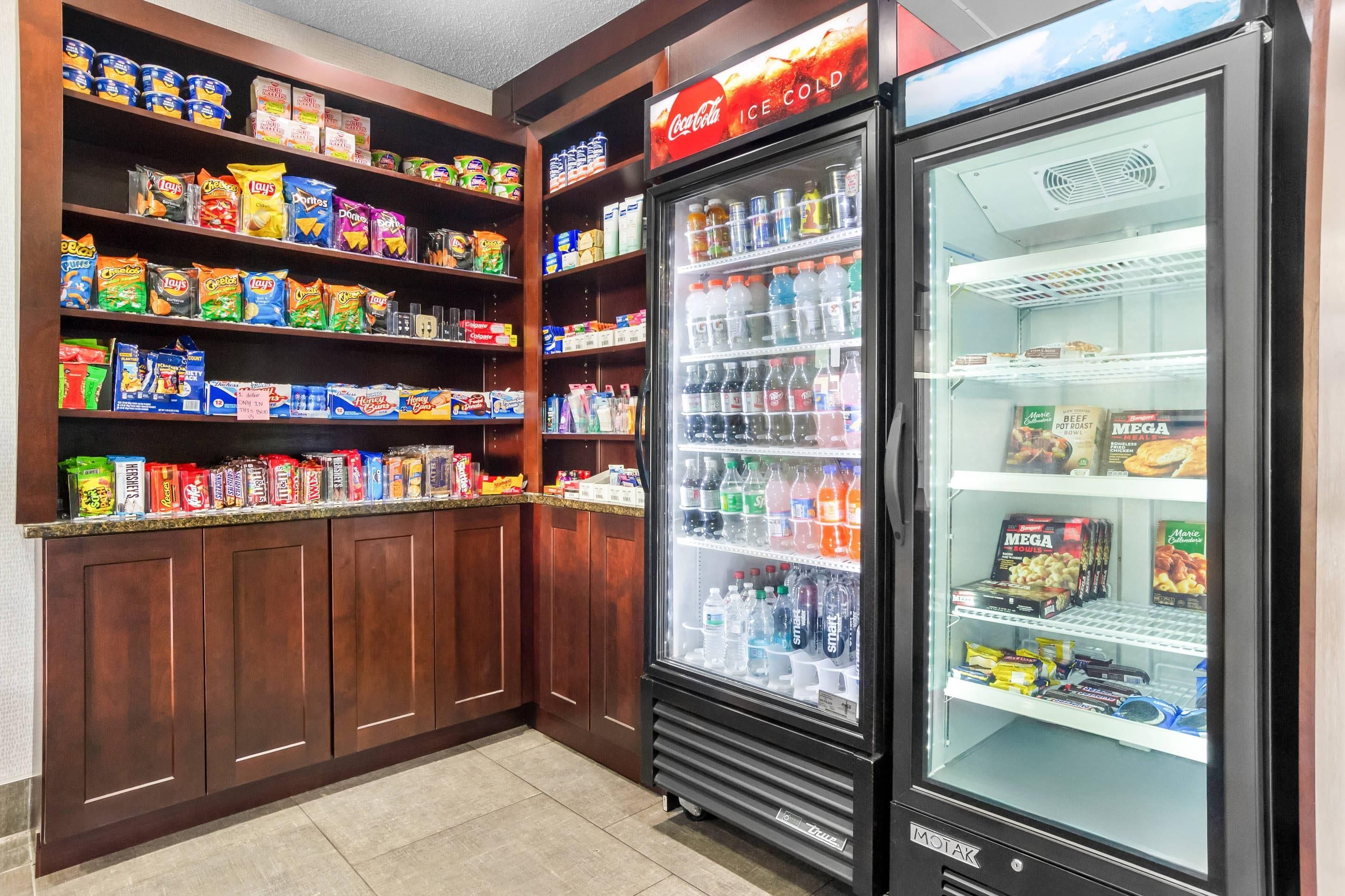 A vending machine stocked with snacks and beverages, including chips and sodas, in a commercial setting.