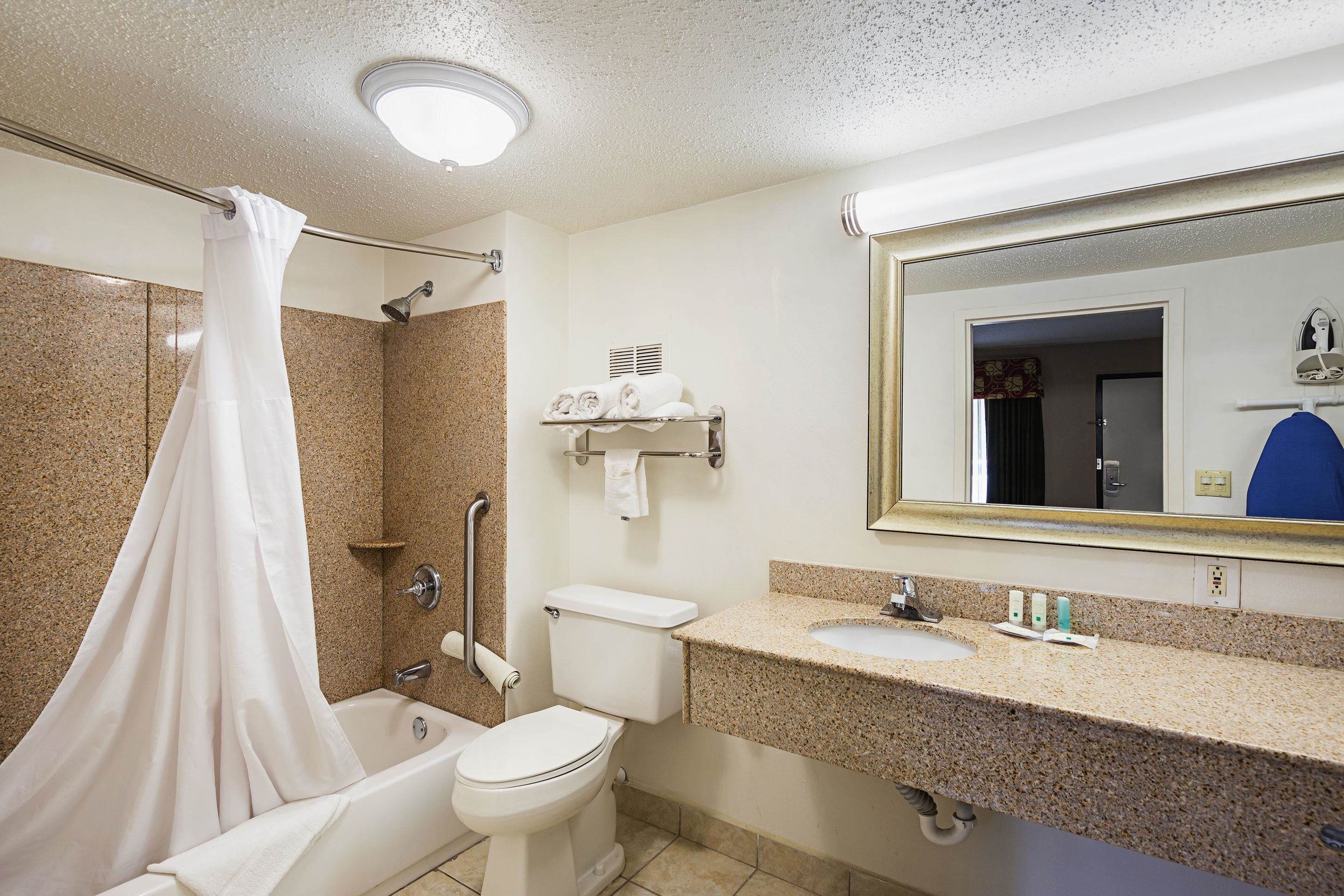 A bathroom with a bathtub, toilet, and sink.