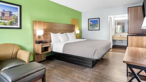 A hotel room with a bed, a desk, a chair, and a TV. - Quality Inn & Suites Greenville - Haywood Mall (Greenville)
