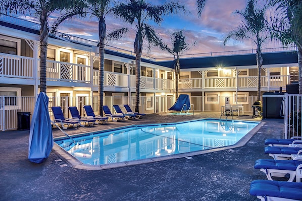 Una piscina al aire libre, sillones reclinables de piscina