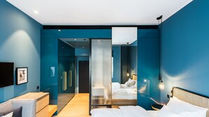 A modern bedroom with a bed, a sofa, and a walk-in closet. - Hotel Maximilian (Prague)