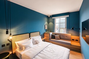 Una camera da letto moderna con un letto grande, un divano e un comodino.