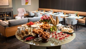 A buffet table with various food items and a seating area with tables and chairs. - Hotel Maximilian (Prague)