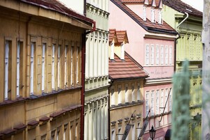 Una fila di edifici colorati con stili architettonici differenti, tra cui un edificio rosa con un'insegna che recita 'Hotel'.