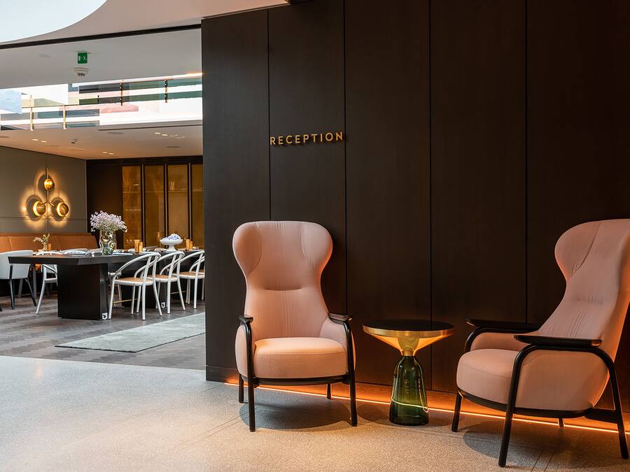 A reception area with two plush chairs, a small table, and a reception desk.