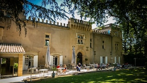 Un edificio histórico con terraza exterior y jardín.