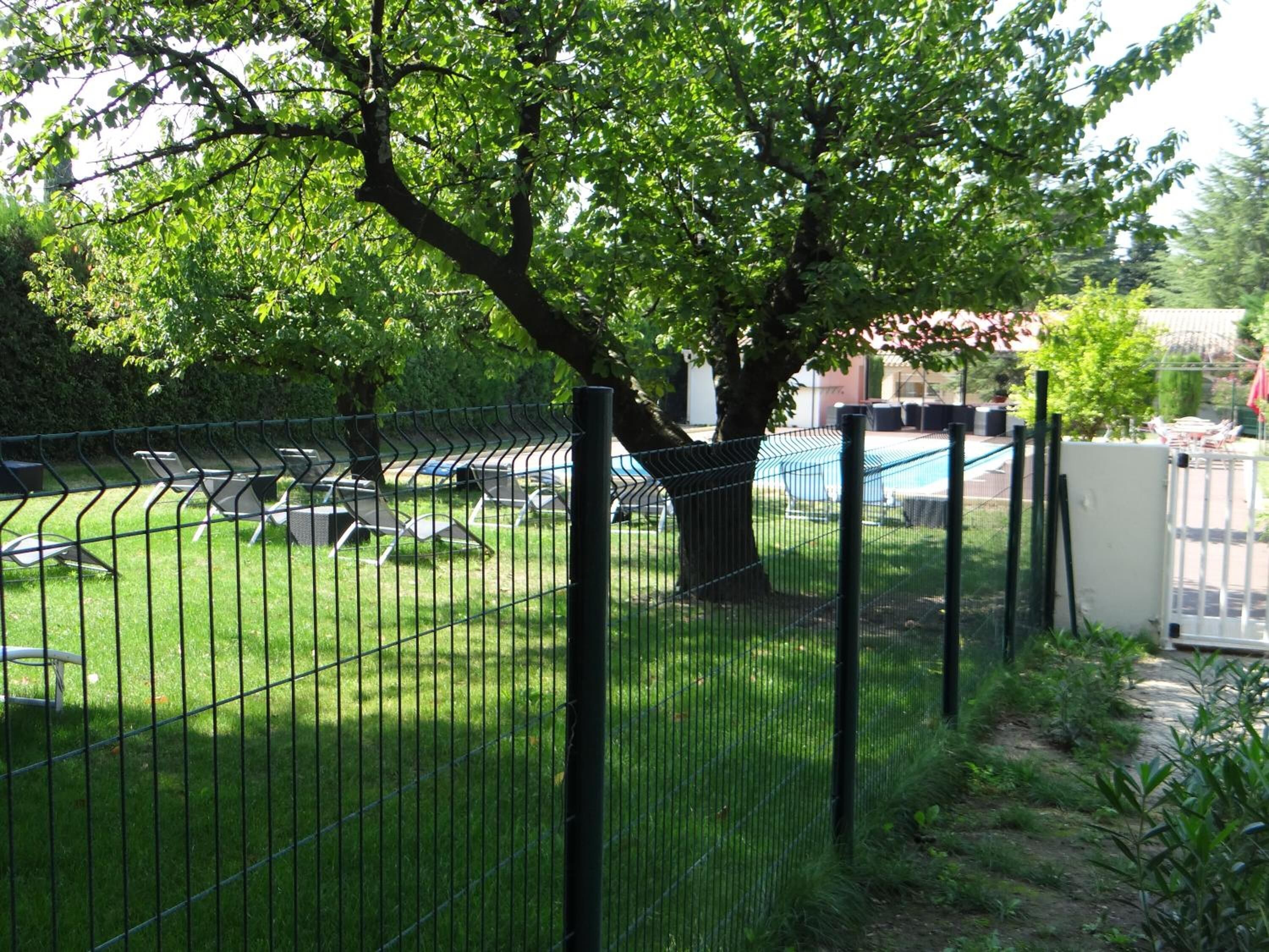 Un espace extérieur clos, aménagé avec des chaises longues et une piscine.