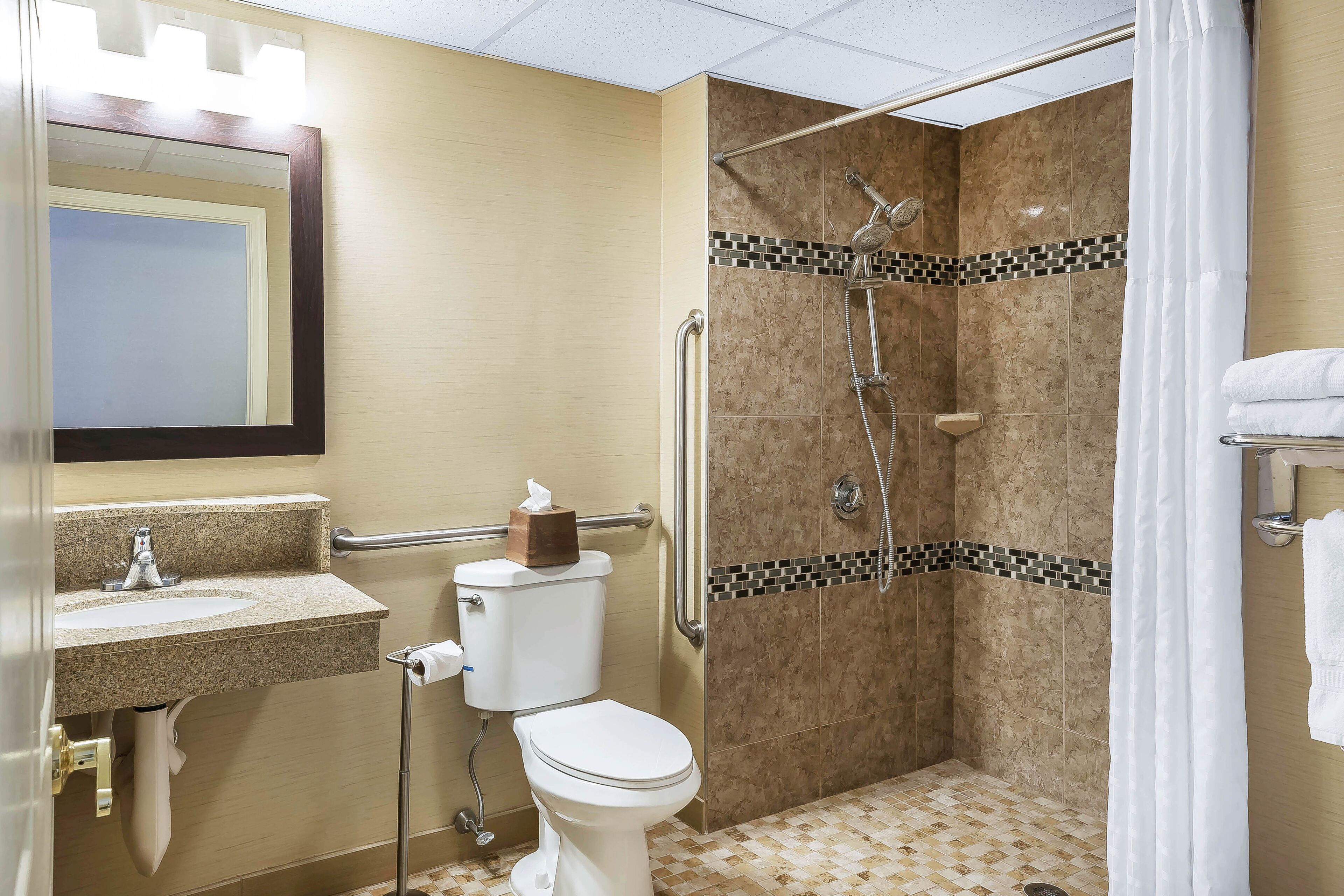 A bathroom with a toilet, sink, and shower.