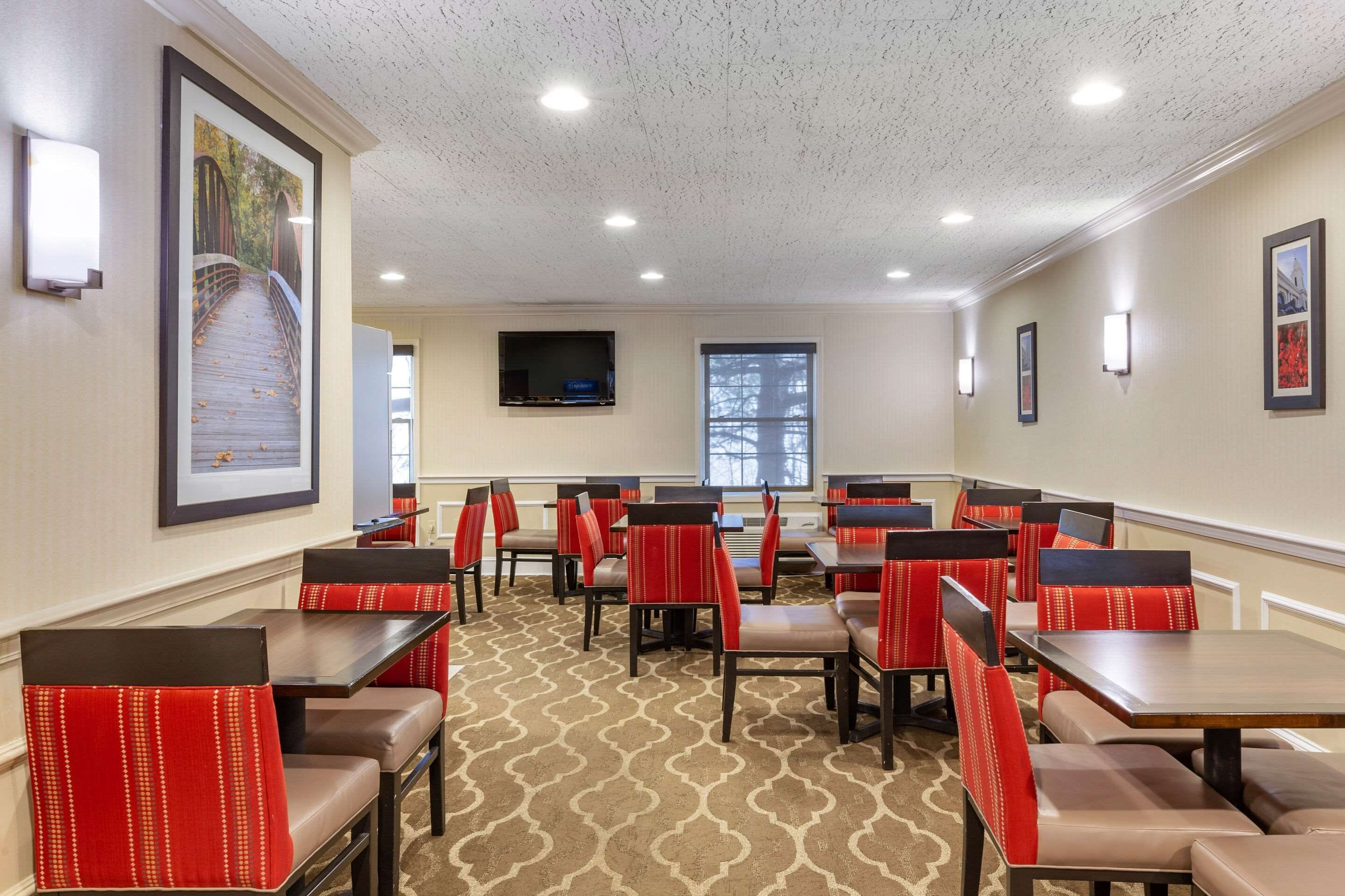 A restaurant with booths and tables, a patterned carpet, and framed pictures on the walls.