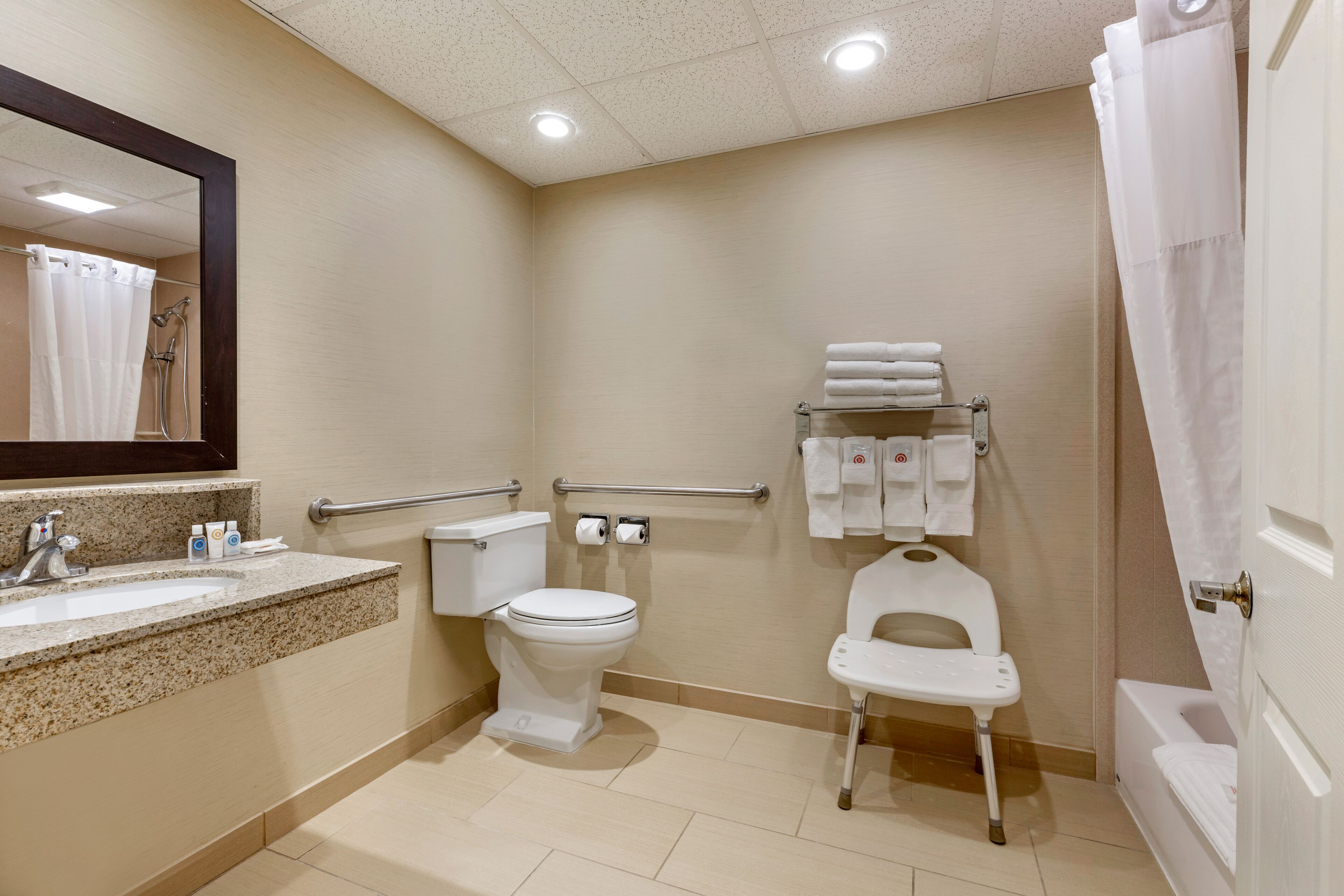 A bathroom with a sink, toilet, bidet, and a shower curtain.