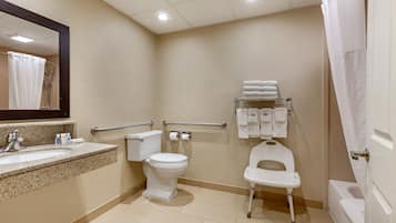 A bathroom with a sink, toilet, bidet, and a shower curtain.