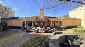 A patio with outdoor seating, a chimney, and a pathway leading to a building. - Hotel Preston (Montgomery)