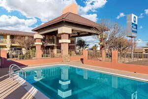 Una piscina al aire libre, tumbonas