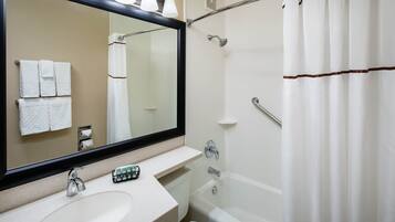 A bathroom with a sink, mirror, shower, and toilet.