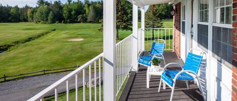 A porch with a view of a golf course.