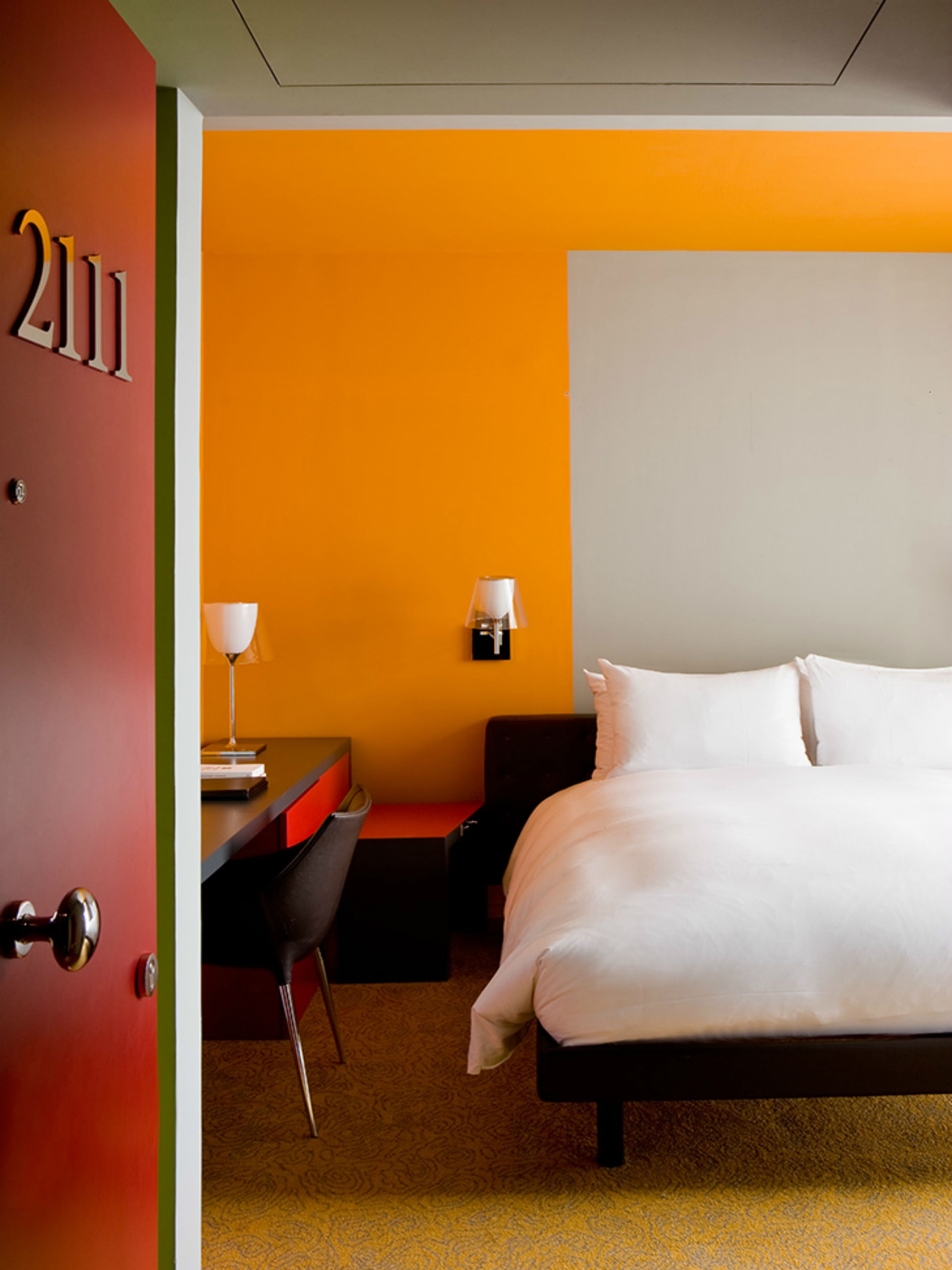 Une chambre d’hôtel avec un lit, un bureau et une chaise.