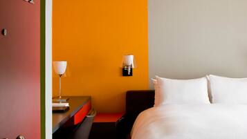 Une chambre d’hôtel avec un lit, un bureau et une chaise.