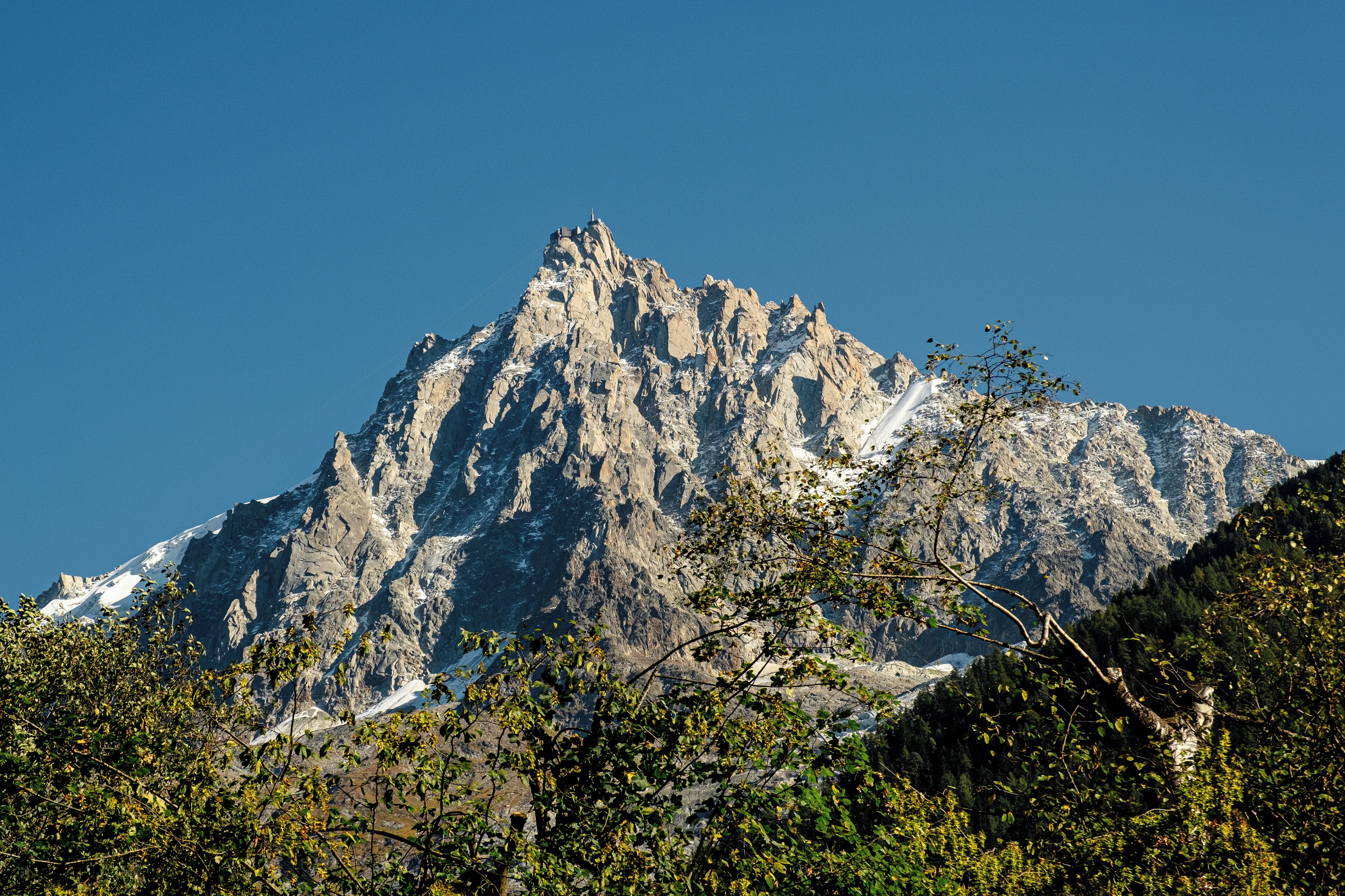 Ein Berg mit felsigem Gipfel und Schneeflächen.