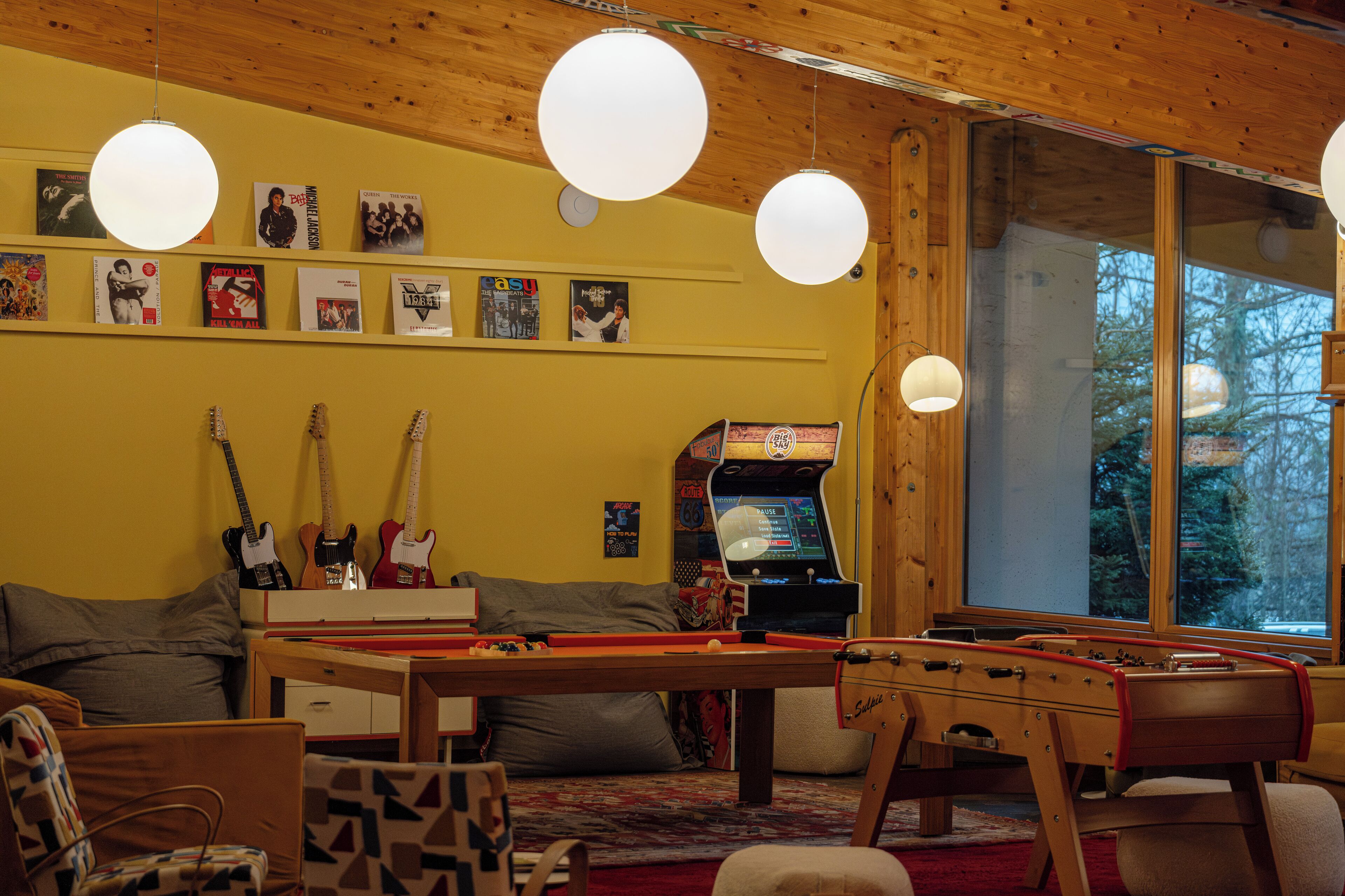Ein gemütliches Zimmer mit Billardtisch, Kicker und Gitarren an der Wand.