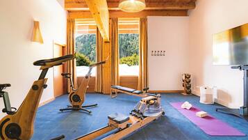Un gimnasio con equipamiento para ejercicio, una colchoneta de yoga y vistas al exterior.