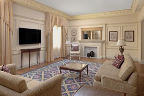 A spacious living room with a large flat-screen TV, a fireplace, and comfortable seating.