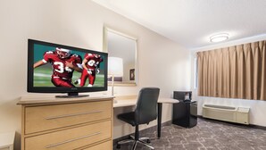 A hotel room with a flat-screen TV, a desk, a chair, a dresser, a mirror, a window with curtains, and a carpeted floor. - Red Roof Inn Seattle Airport - SEATAC (SeaTac)
