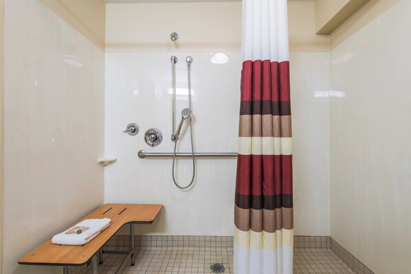 A bathroom with a shower, a bench, and a towel. - Red Roof Inn Seattle Airport - SEATAC (SeaTac)