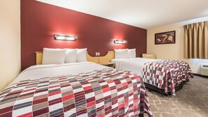 A hotel room with two beds, a red accent wall, and a painting on the wall. - Red Roof Inn Seattle Airport - SEATAC (SeaTac)