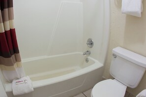 A bathroom with a bathtub, toilet, and a towel rack. - Red Roof Inn Seattle Airport - SEATAC (SeaTac)