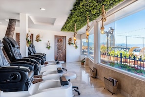 A spa with massage chairs, a wooden door, and a view of a bridge. - Hotel Casa Dona Susana by Los Arcos (Puerto Vallarta)