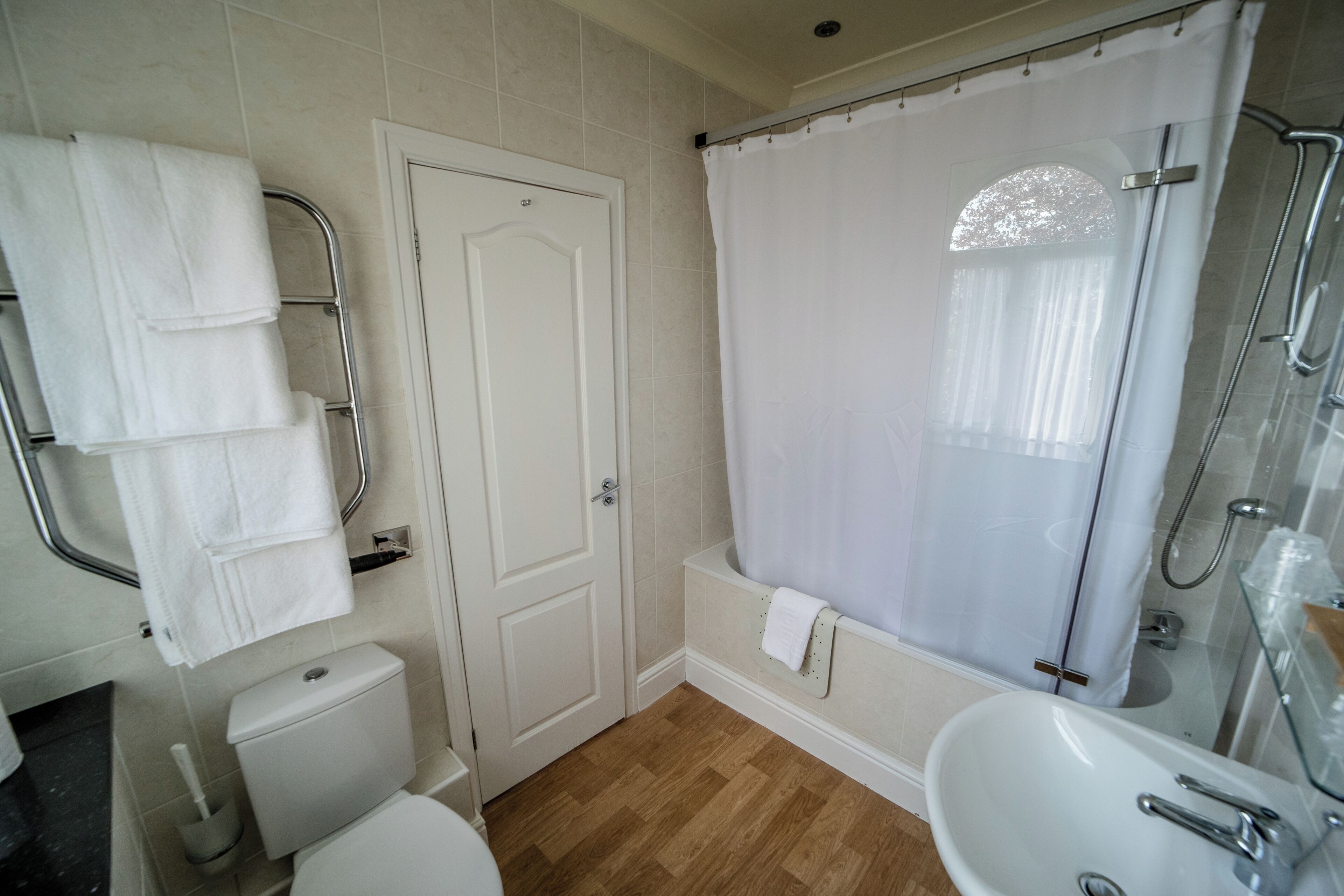 Une salle de bain comprenant des toilettes, un lavabo, une douche et un porte-serviettes.