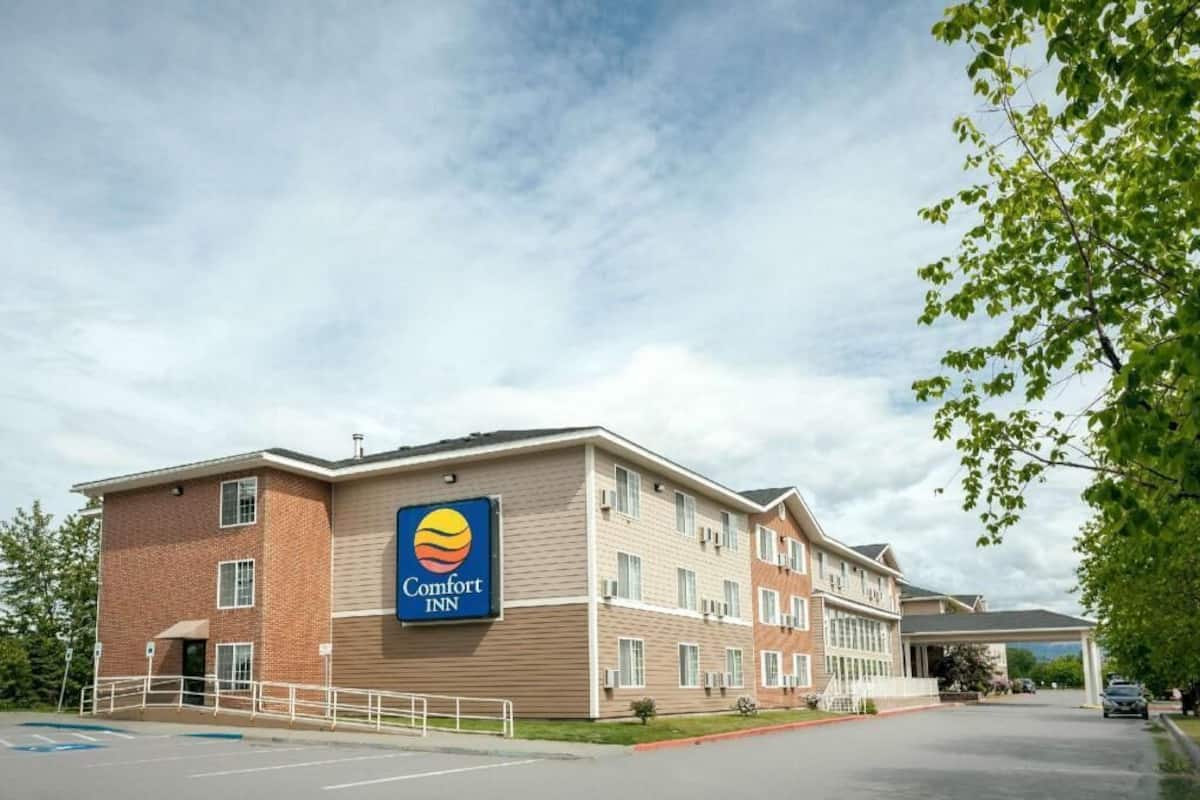 A Comfort Inn hotel with a brick facade, multiple windows, and a parking lot.