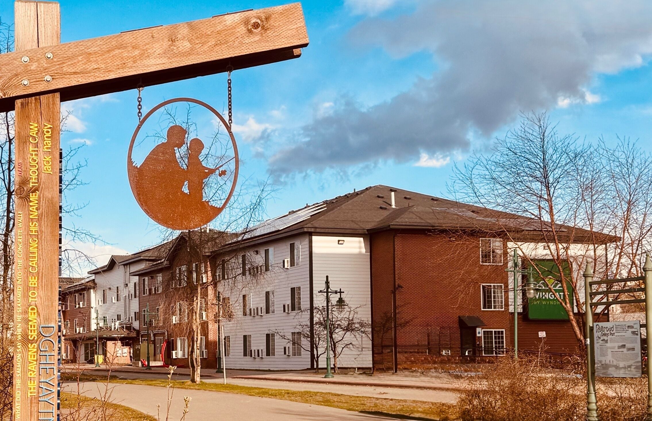 A building with a large garage door, a brick facade, and a sign with a silhouette of a person playing a guitar.