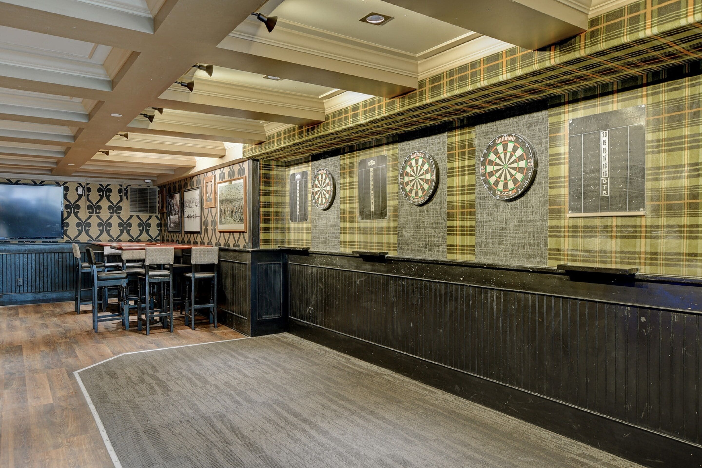 A bar area with dartboards, a bar counter, and seating.