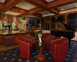 Zona de bar con un piano y asientos.