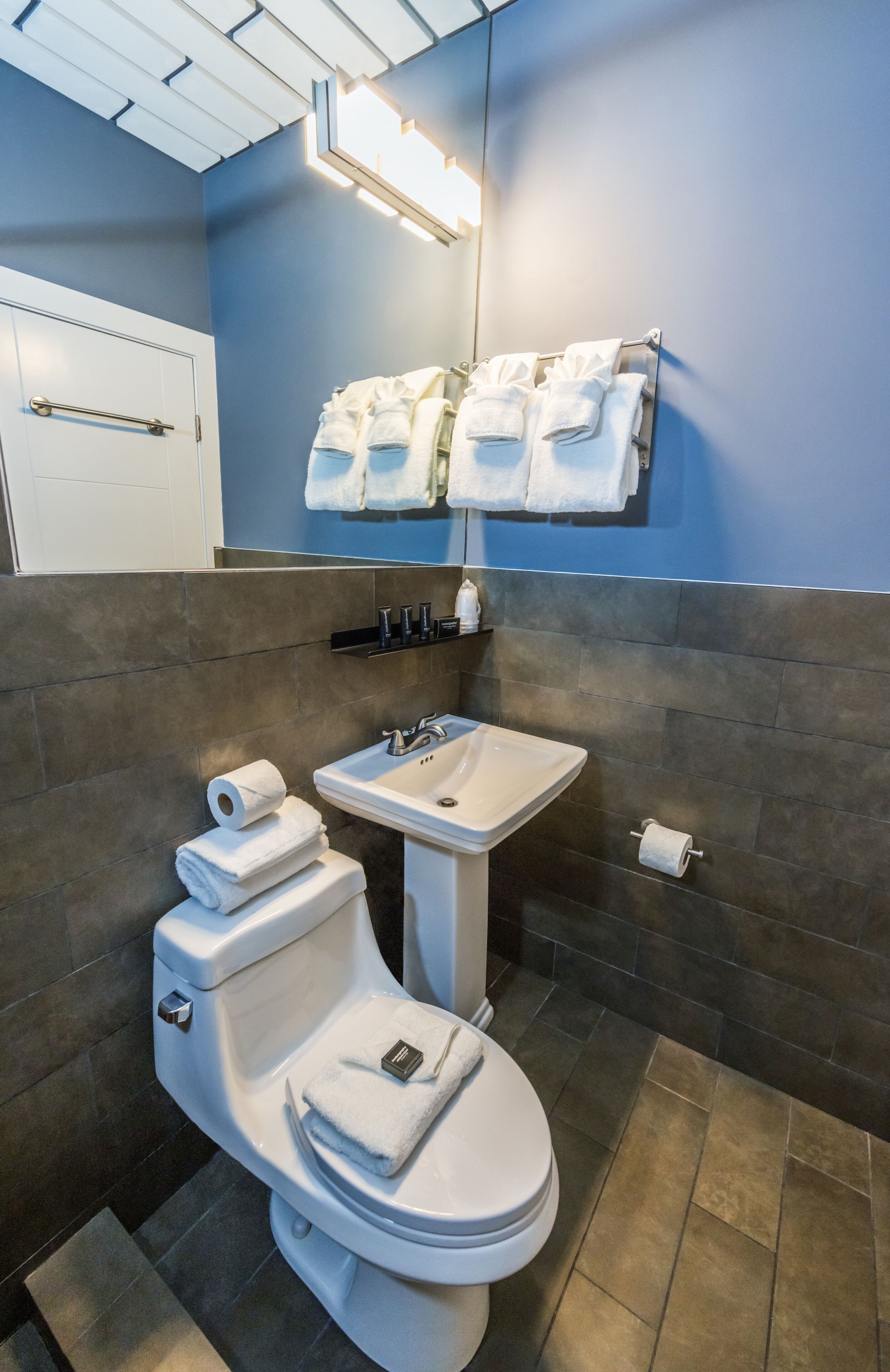A modern bathroom with a toilet, sink, and towel rack.