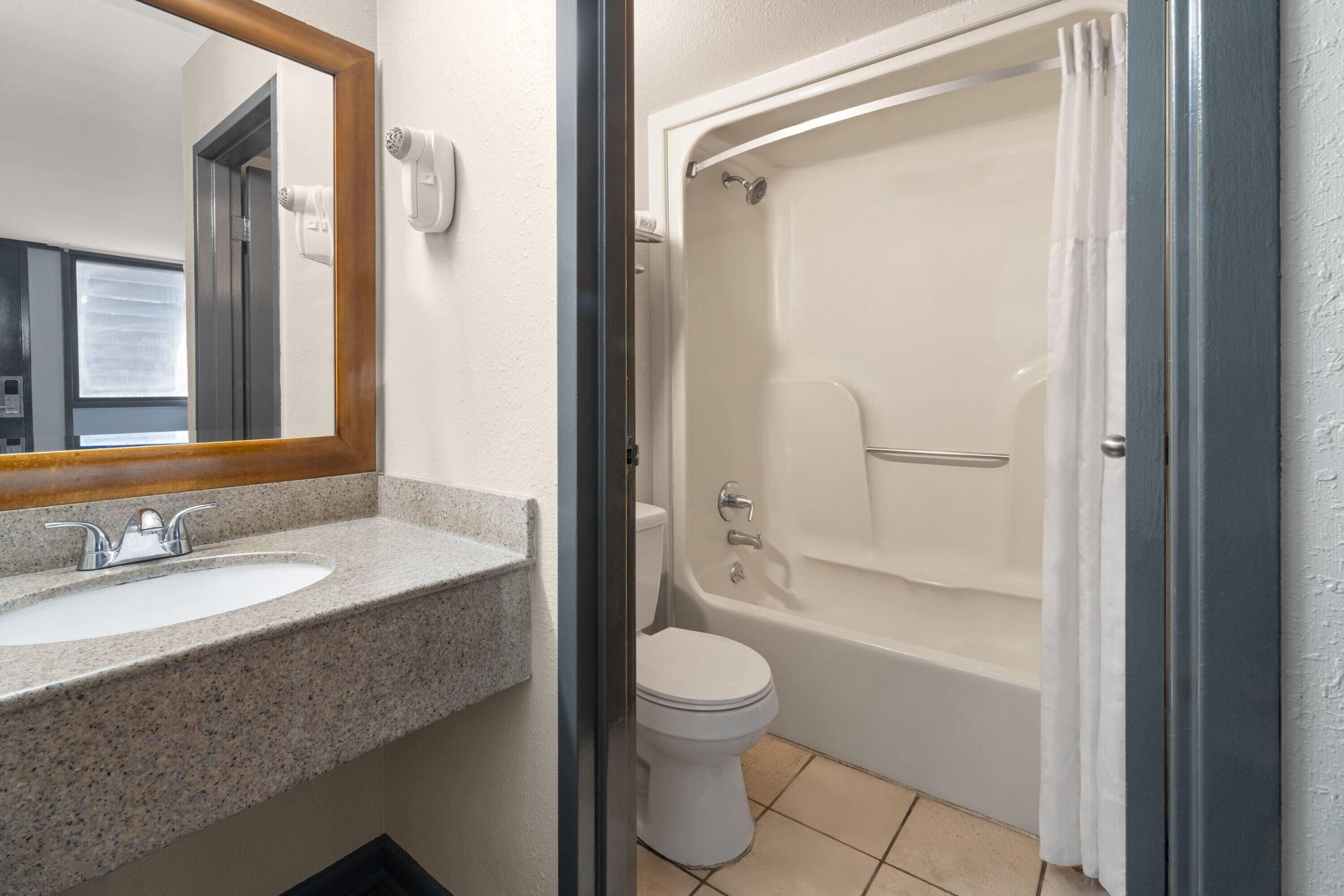 Een badkamer met een wastafel, toilet en bad.