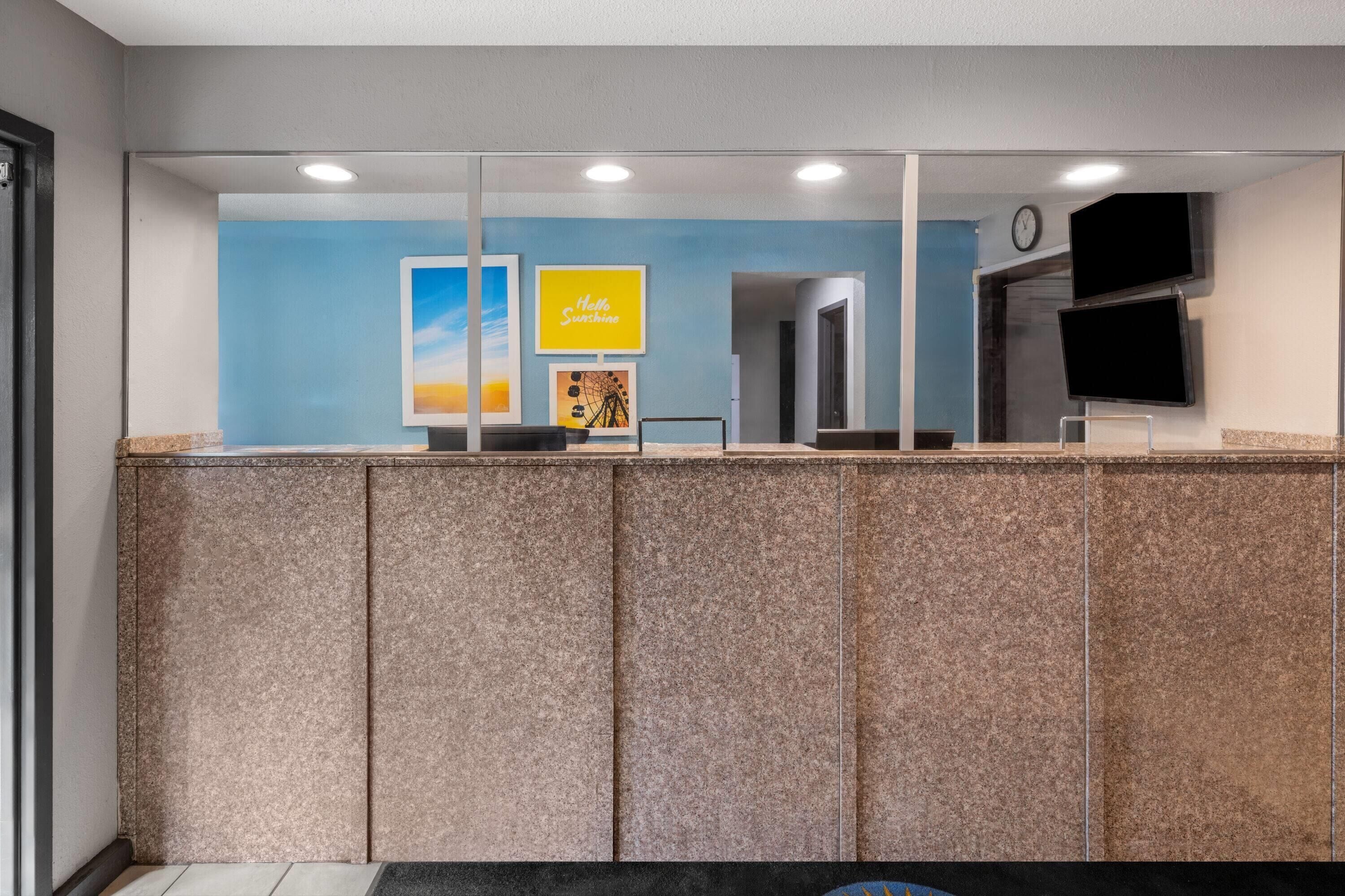 A reception area with a counter, a clock, and framed artwork on the wall.