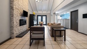 Un salon moderne avec une cheminée, un canapé, une table basse et un téléviseur fixé au mur.
