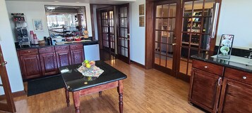 A kitchen with wooden cabinets, a black countertop, and a dining table with fruits.