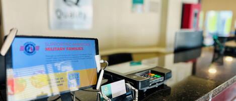 A reception desk with a sign supporting America's military families, a computer monitor, and a card reader.
